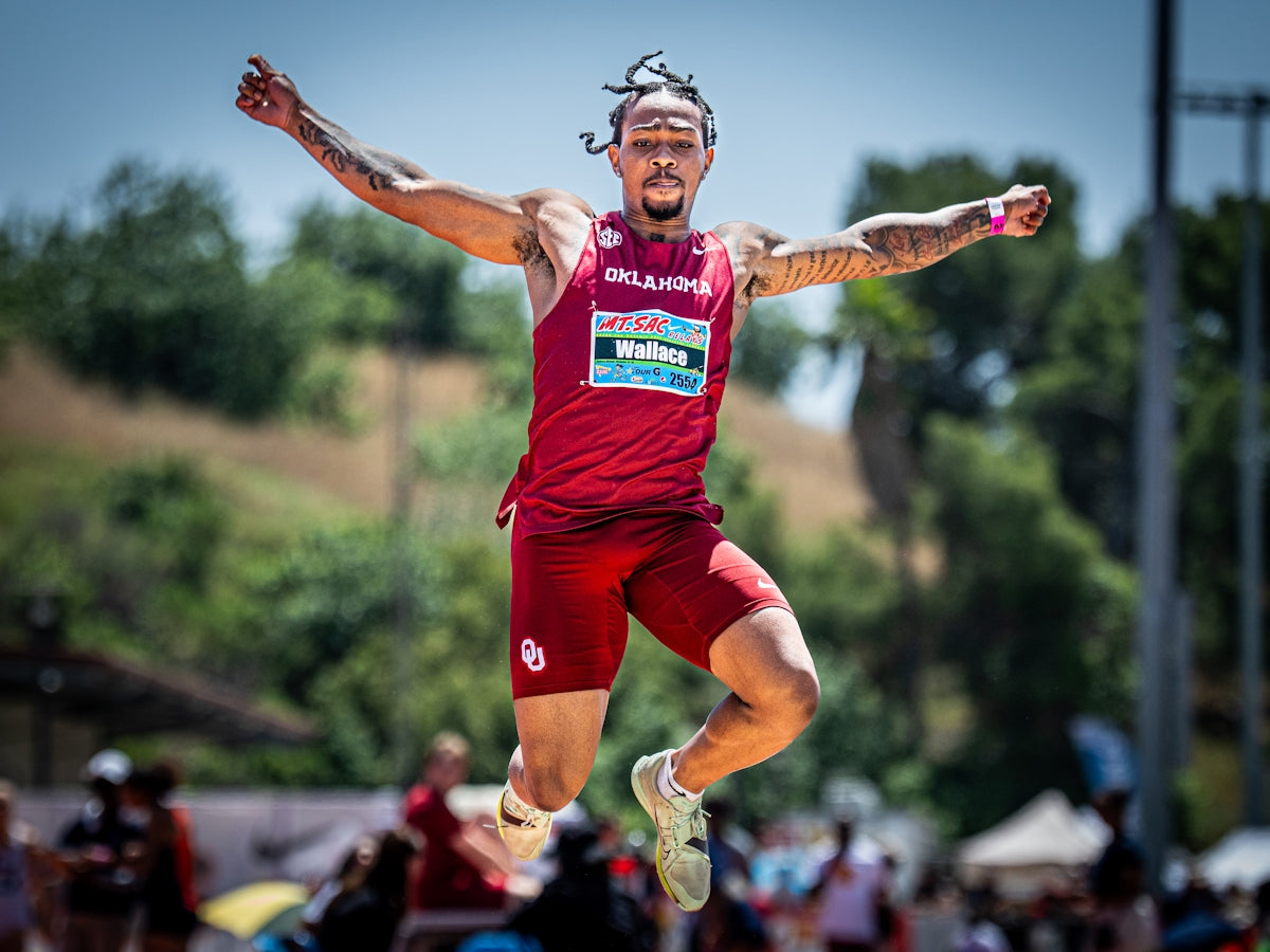 Athlete in mid-air during a long jump competition.