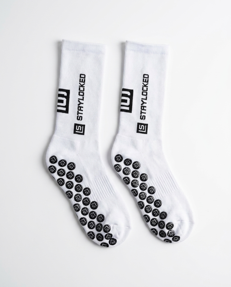 Pair of StayLocked white grip socks, flat lay showing the full grip-pad sole pattern